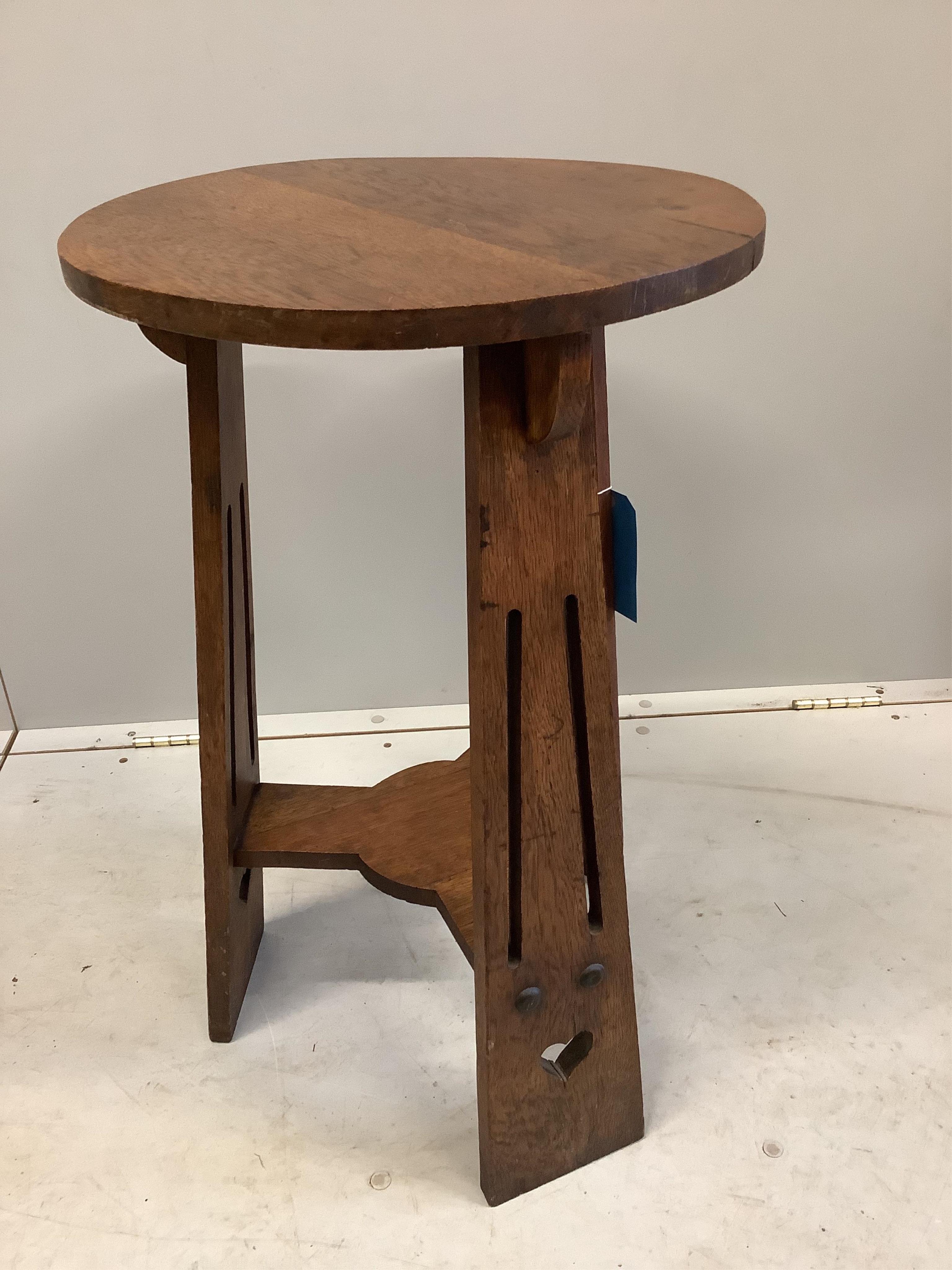 An Arts and Crafts circular oak two tier table, diameter 42cm, height 68cm. Condition - fair